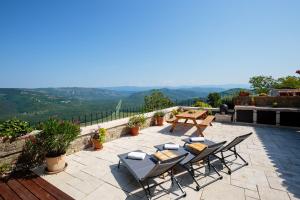 um pátio com cadeiras, uma mesa de piquenique e uma vista em Casa Histria em Motovun