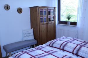 1 dormitorio con 2 camas, armario y ventana en Ferienwohnung Sauerland Feeling, en Olsberg