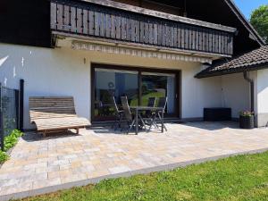 a patio with a bench and a table and chairs at Ferienwohnung Sauerland Feeling in Olsberg
