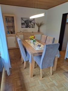 comedor con mesa de madera y sillas azules en Ferienwohnung Sauerland Feeling, en Olsberg