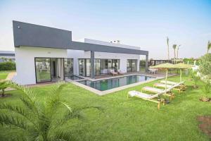 uma casa grande com piscina no quintal em Villa Alanaé avec piscine chauffée em Marrakech
