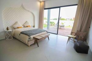 sypialnia z dużym łóżkiem i balkonem w obiekcie Villa Alanaé avec piscine chauffée w Marakeszu