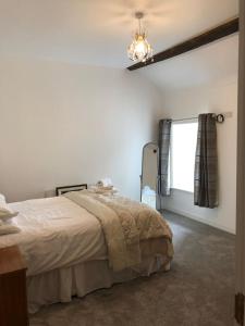 ein Schlafzimmer mit einem großen Bett und einem Kronleuchter in der Unterkunft Perfect Apartment in ideal location in Ennistymon