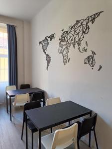 una habitación con 2 mesas y un mapa mundial en la pared en A Plus Hostel - Centrum, en Praga
