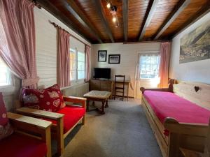 Un dormitorio con una cama, un sofá y un televisor. en Cotterg - Chalet individuel 15 pers, centre village et proches pistes de ski, en La Clusaz