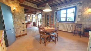 une cuisine et une salle à manger avec une table et des chaises dans l'établissement La Bandita Cottage, à San Venanzo