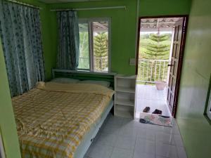 a small bedroom with a bed and a window at Lovely Farm in Khao Kho