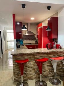een keuken met rode kasten en rode barkrukken bij House in Malaga in Málaga