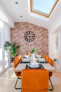 a dining room with a table and chairs and a brick wall at Modern 4 Bed Chester Townhouse with FREE Parking in Christleton