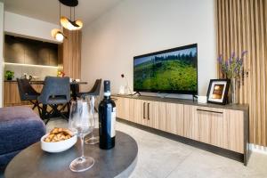 ein Wohnzimmer mit einer Flasche Wein und einem TV in der Unterkunft Apartamenty Laguna Beskidów - A95 in Zarzecze