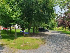 um sinal de rua com um carro estacionado num parque em Le domaine du château blanc à 10 minutes de Paira Daiza em Jurbise