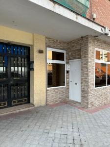 ein Gebäude mit einer weißen Tür und einigen Fenstern in der Unterkunft Apartamentos Redondela in Madrid