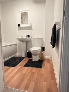 ein Badezimmer mit einem weißen WC und einem Waschbecken in der Unterkunft Cozy 2bed apartment w/ parking in Swindon