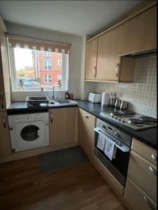 eine Küche mit einer Spüle und einer Waschmaschine in der Unterkunft Cozy 2bed apartment w/ parking in Swindon