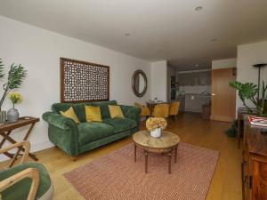 uma sala de estar com um sofá verde e uma mesa em Pass the Keys Stylish comfortable apartment in central Kingston em Kingston upon Thames