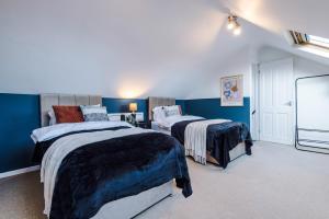 two beds in a room with blue walls at Modern 4 Bed Chester Townhouse with FREE Parking in Christleton