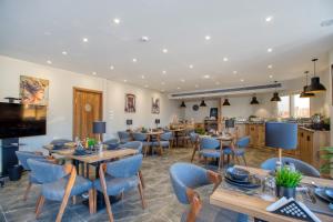 a restaurant with wooden tables and blue chairs at NOZOL PYRAMIDS HOTEL in Cairo