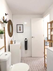 La salle de bains blanche est pourvue de toilettes et d'un lavabo. dans l'établissement Coqueto apartamento a un minuto de Cala Blanca, à Cala Blanca