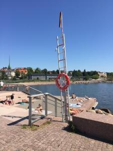 people laying on the beach near the water with a ladder at Luxury City Seafront Apartment with Balcony in Helsinki +19 photos