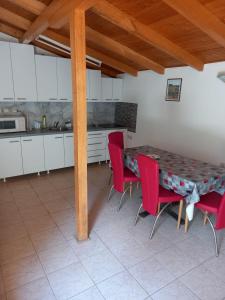 a kitchen with a table and red chairs in a room at Apartmani Pasuljevic in Veliko Gradište