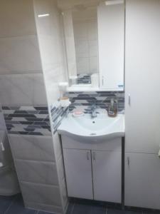 a bathroom with a white sink and a mirror at Apartmani Pasuljevic in Veliko Gradište