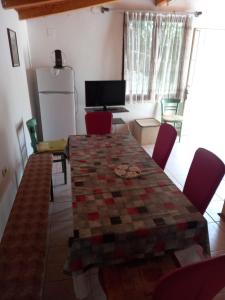 cocina con mesa, sillas y nevera en Apartmani Pasuljevic, en Veliko Gradiste