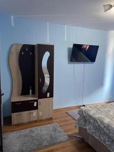 a bedroom with a bed and a tv on a wall at MEHTUP SRL in Piteşti
