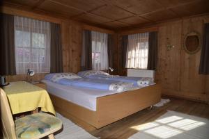 a bedroom with a large bed in a room with wooden walls at Apartement Schuster Lake Prags Braies in Braies