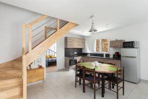 a kitchen and dining room with a table and a staircase at Maison neuve au centre-ville proche de l'aéroport in Guipavas +7 photos