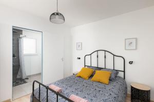 1 dormitorio con 1 cama con 2 almohadas amarillas en Maison neuve au centre-ville proche de l'aéroport, en Guipavas