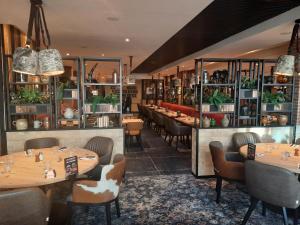 a restaurant with tables and chairs and a bar at Hôtel Forest Hill Meudon Velizy in Meudon