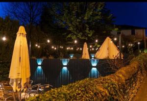 una piscina de agua con sombrillas y luces en Kirkhouse Inn, en Milngavie