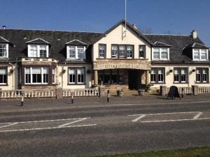 a large building on the side of a street at Kirkhouse Inn in Milngavie
