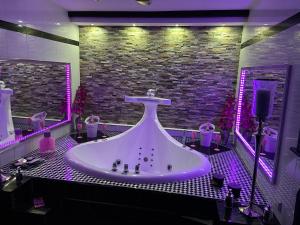 La salle de bains est pourvue d'une grande baignoire avec des lumières violettes. dans l'établissement VIP Haus Winterberg, à Winterberg