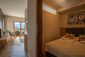 a bedroom with a bed and a table and chairs at RentPlanet - Green Park Resort in Szklarska Poręba