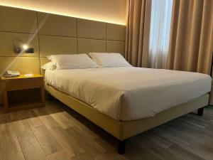- un lit dans une chambre d'hôtel avec un téléphone sur une table dans l'établissement Best Western Cavalieri Della Corona, à Cardano al Campo