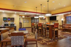 a restaurant with tables and chairs and a bar at Hampton Inn Dry Ridge in Dry Ridge