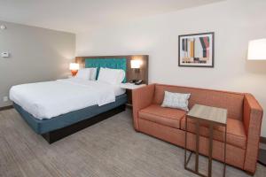 a hotel room with a bed and a couch at Hampton Inn Dry Ridge in Dry Ridge
