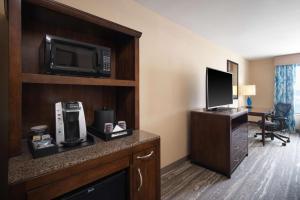 a hotel room with a microwave and a television at Hilton Garden Inn Houston/Bush Intercontinental Airport in Houston