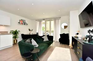 un soggiorno con divano verde e una cucina di Chic 2 Bed Riverside Retreat a Rochester