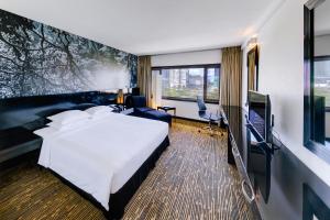 コロンボにあるシナモン レイクサイドのベッド1台、薄型テレビが備わるホテルルームです。