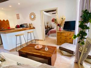 a room with a kitchen and a living room with a table at Appart Karibu in Callian