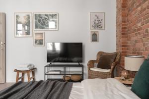 a living room with a bed and a flat screen tv at HARBOR APARTMENTS - Damrota in Katowice