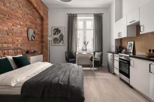 um quarto com uma cama e uma parede de tijolos em HARBOR APARTMENTS - Damrota em Katowice