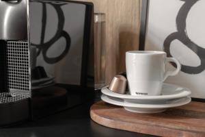 eine Kaffeetasse auf einem Tisch neben einem Spiegel in der Unterkunft HARBOR APARTMENTS - Damrota in Kattowitz