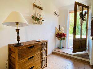 a lamp and a dresser in a room with a window at Appart Karibu in Callian +9 photos