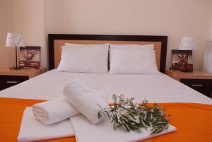 a bed with two towels and a plant on it at Sofia Luxury Maisonettes in Nikiti