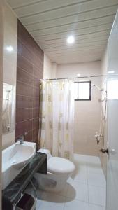 a bathroom with a toilet and a sink and a shower at Verano GuestHouse in Tagbilaran City