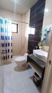 a bathroom with a toilet and a sink and a shower at Verano GuestHouse in Tagbilaran City