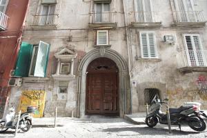 un scooter garé devant un bâtiment avec porte dans l'établissement Cartoline di Napoli, à Naples
